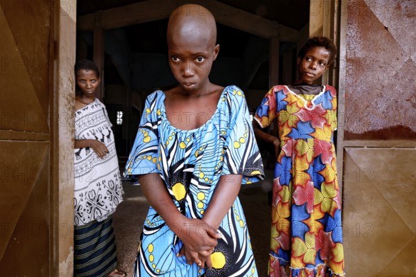 Three woman with different clothes stand in a door and look calmly at the camera, Bouké, region,
