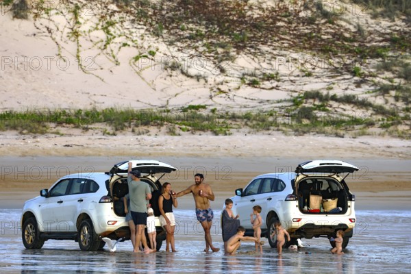 Beach visitors stand next to cars on the sandy beach of Cable Beach, Broome, Broome, Western