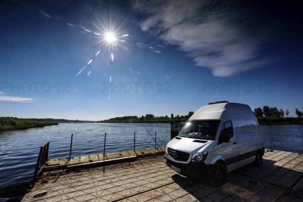 Sprinter on a ferry in bright sunshine across the Daugava, Dunava, Latvia
