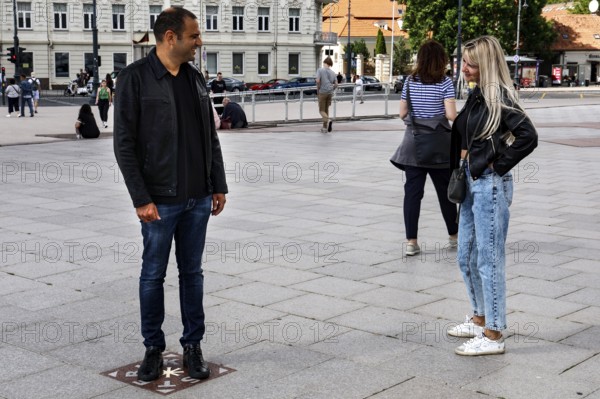 A couple talking on the miracle tile on Cathedral Square in Vilnius, Vilnius, Vilnius County,