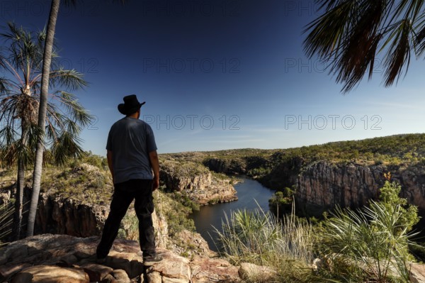 Person standing at a lookout overlooking the river and rocky landscape at Pat's Lookout, Katherine