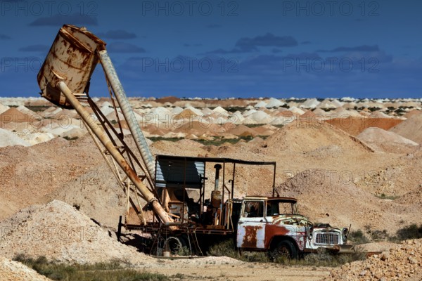 Mining machine in the opal mining area of Coober Pedy, surrounded by desert and blue sky, Coober