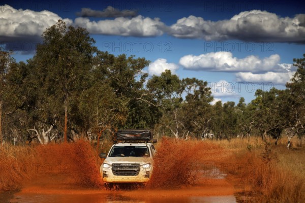 SUV crosses a muddy ford along Gibb River Road, Gibb River Road, Western Australia, Australia