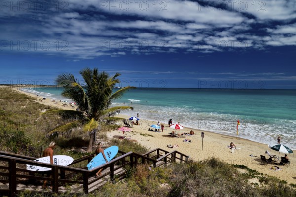 Beach with coconut trees, wooden walkway and colorful umbrellas on Cable Beach, Broome, Western