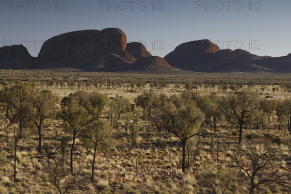 Wide desert-like landscape with distinctive rock formations in the distance, zero