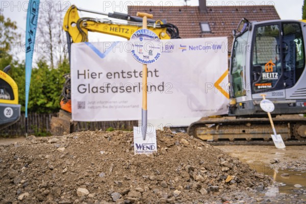 Construction site for fibre-optic expansion with excavators and signs in the background, fiberglass
