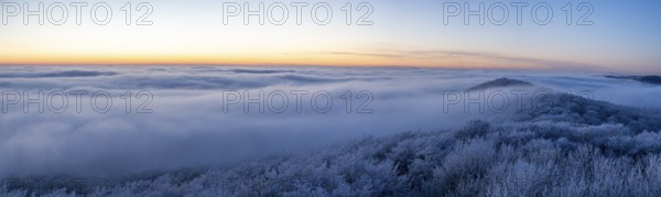 Wide, snowy landscape under a calm sky at dusk, panoramic view of the Teutoburg Forest from an