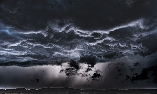 Threatening storm clouds criss-cross the dark sky, Osnabrücker Land, Wiehen Mountains, Lower