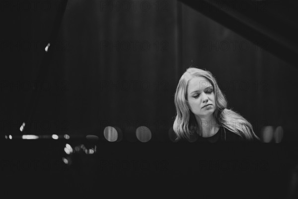 Boy, woman, pianist, with concentrated facial expression and closed eyes playing on a Steinway &