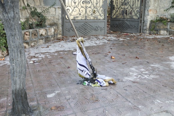 In Aleppo, Syria on January 10, 2026, a burned flag of the SDF (Syrian Democratic Forces) lies