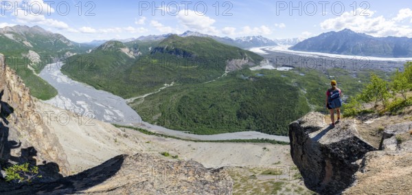 Panorama, young woman on a rocky outcrop enjoying the view, view of impressive mountain landscape