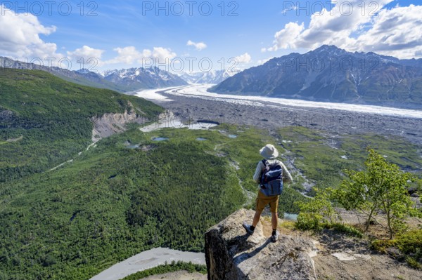 Young man on a rocky outcrop enjoying the view, view of impressive mountain scenery with Matanuska