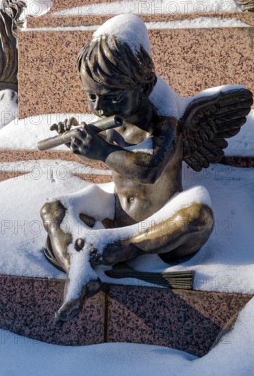 An angel playing the flute, figure at the Felix Mendessohn Bartholdy monument in winter with snow,