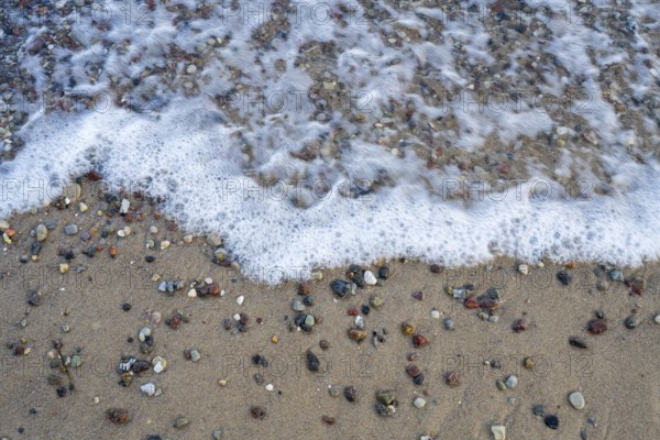 Pebbles on the coast surrounded by water, view from above, Baltic Sea, Rügen island,