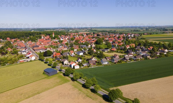 Panoramic summer view of a village with red roofs and wide fields, Adenstedt, Ilsede municipality,