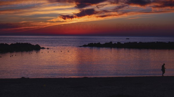 Twilight landscape with sunset, dramatic sky and silhouette of people on the beach (Playa Flamingo)