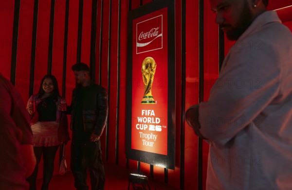 Football fans poses for a photograph with the original FIFA World Cup 2026 Trophy during the