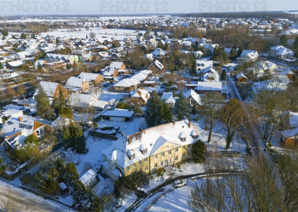 Residential area in winter with snow-covered classic buildings and trees, aerial view,