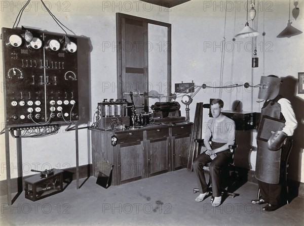 X-ray, hospital, man wearing a heavy apron, face mask and gloves to protect against X-rays,