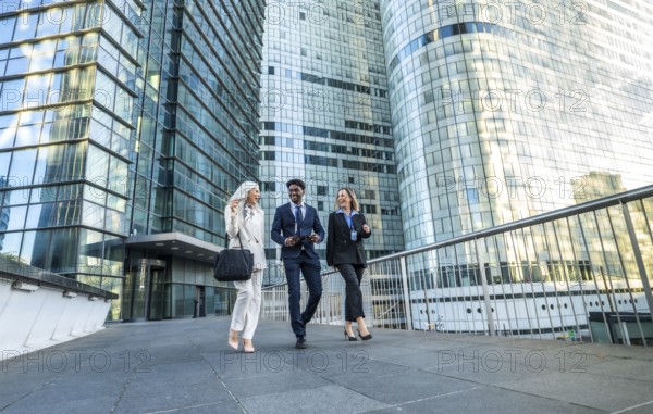 Diverse business professionals walking, communicating, and laughing while moving together in a