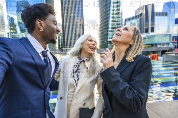 Diverse business team colleagues laughing together while standing outdoors in the city, enjoying a