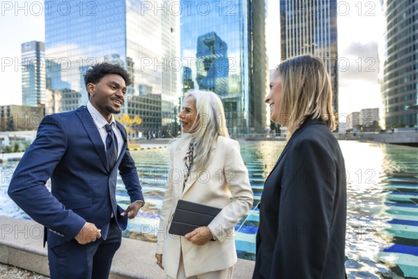 Diverse business professionals having a dynamic informal meeting and discussing ideas outdoors in a