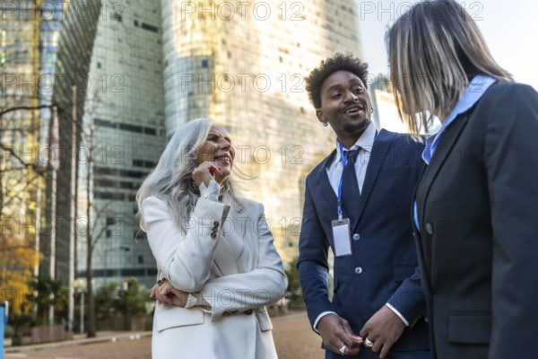 Diverse business professionals sharing a cheerful conversation and networking outdoors in an urban