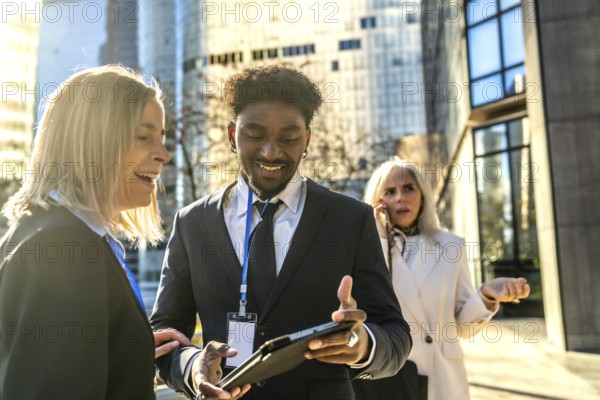 Diverse business people working together outdoors in a city, exchanging ideas and smiling while