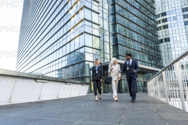 Business professionals of different ages and ethnicities are walking together, smiling, and having