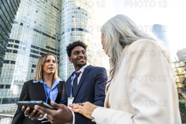 Diverse business professionals discussing projects and ideas during an outdoor meeting in a modern