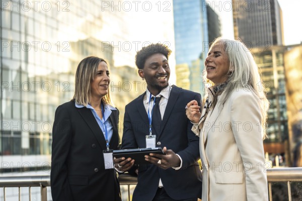Diverse business professionals reviewing information on a digital tablet, fostering teamwork and
