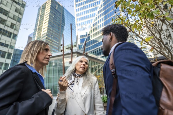 Professionals engaging in a focused conversation outside office buildings, representing