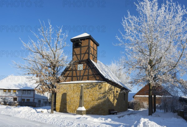 Snowy half-timbered church with blue sky and snow-covered trees in the background, Old Chapel, 15th