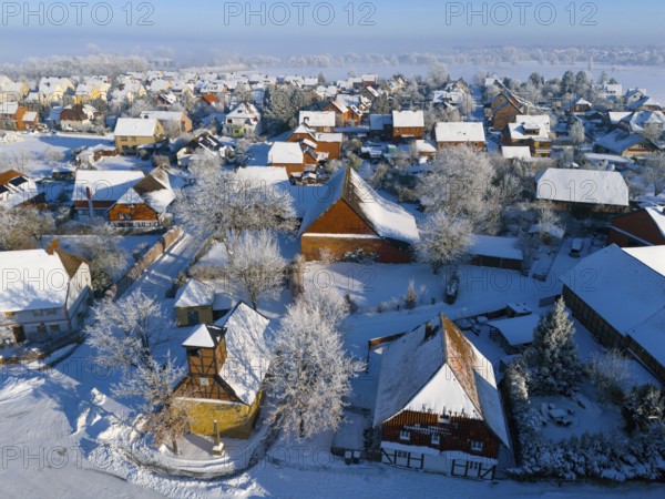 Winter village with snow-covered roofs and half-timbered buildings, cold, peaceful atmosphere,