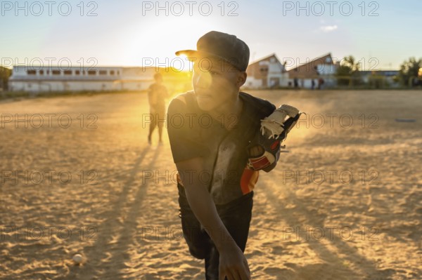 Young baseball player focusing while preparing to throw from the pitcher's mound, wearing a cap and