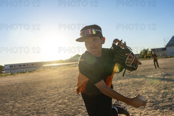 Young baseball player throwing a pitch, wearing a cap and sports goggles, with a baseball glove on