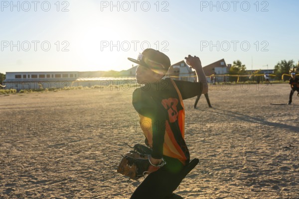 Young baseball player wearing a cap and jersey, preparing to throw the ball during a game on a