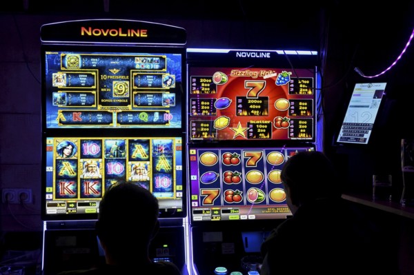 Guests at a pub in front of slot machines, Munich, Bavaria, Germany