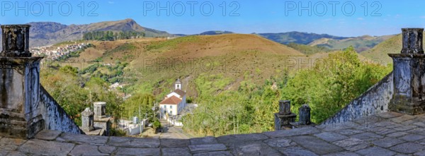 Historic churches and mountains of the city of Ouro Preto seen through stone columns, Ouro Preto,