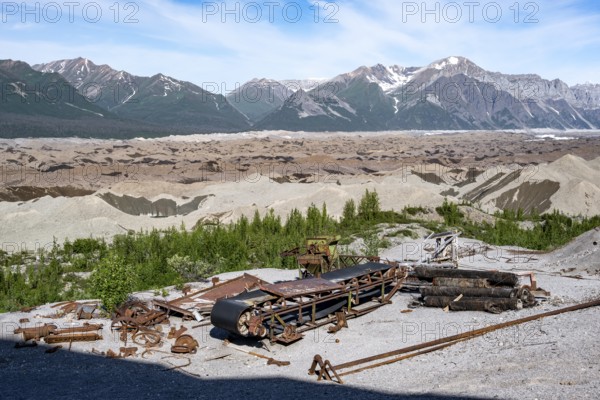 Old rusted metal scrap with conveyor belt, mountainous landscape and Kennicott Glacier, Historic