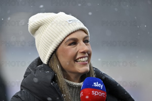SKY reporter presenter Mara Mones wears hat in interview microphone micro logo portrait smiling,
