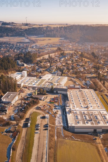 Industrial plants next to a village in a hilly winter landscape, Glatten, Freudenstadt district,