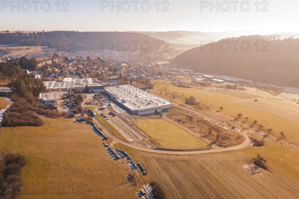 Factory next to a village in a hilly landscape on a winter morning, Glatten, Freudenstadt district,