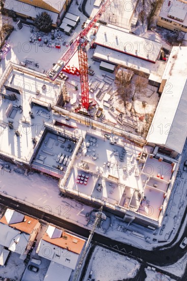 Detailed view of a snowy construction site with visible building materials, Zellerschule new