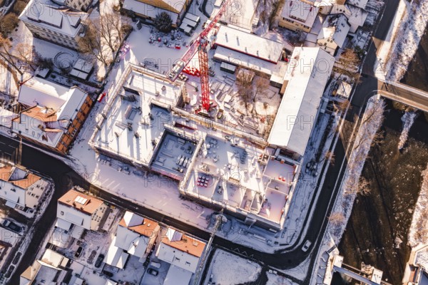 Bird's eye view of a snowy construction site between urban houses, Neubau Zellerschule, Nagold,