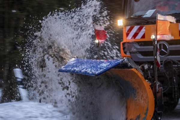 Winter service, spreader and snow plough in use, clears snow and slush from a regional road,