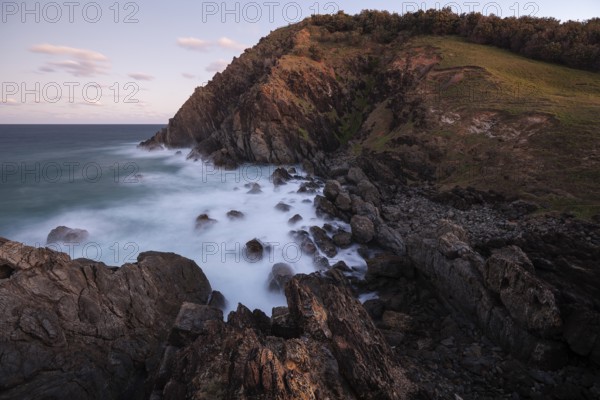 Sunset, Byron Bay, New South Wales, Australia. Waves crashing on rocks at the most easterly point