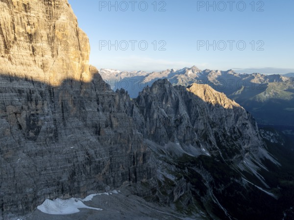 Aerial view, alpine panorama, rocky peaks at sunrise with alpine glow, picturesque mountain