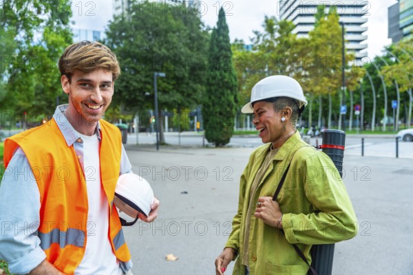 Diverse team of architects and engineers smiling and talking while standing outdoors in the city,