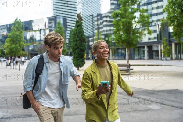 Diverse business colleagues walking on a paved pathway outdoors in a modern city district, sharing